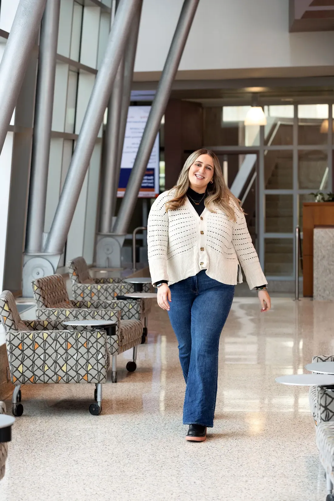 Isabella Simon walking in a building on syracuse University's campus.