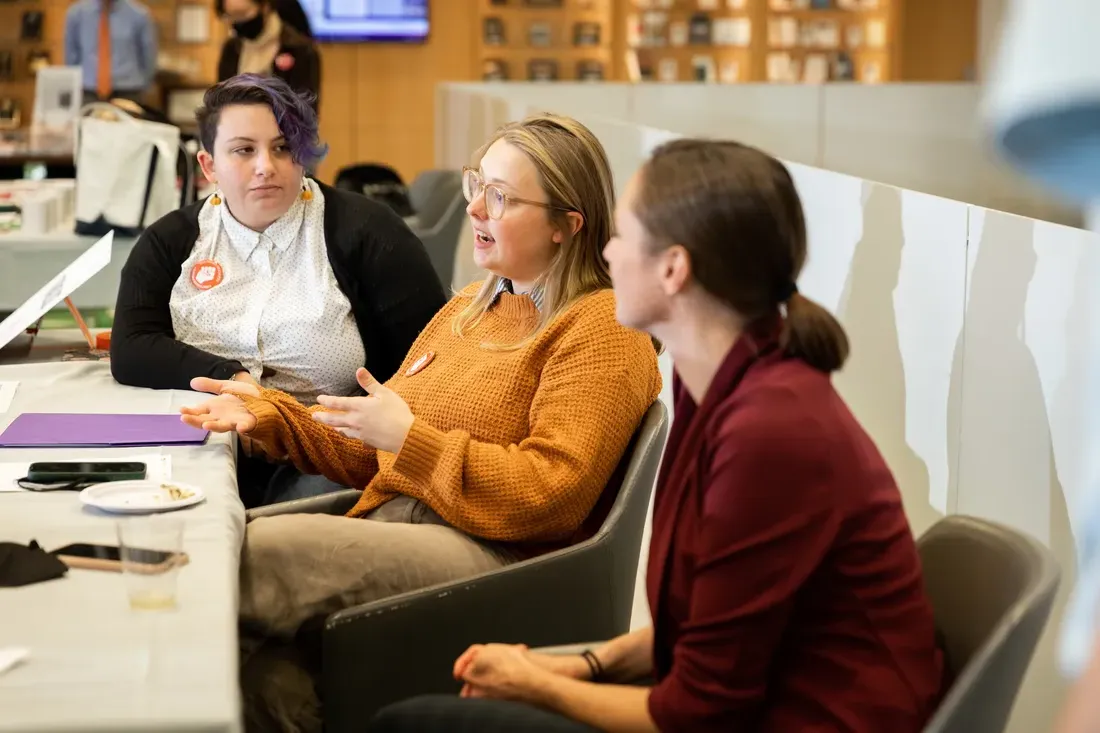 Students sitting at a table and talking.